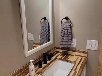 Vanity with butcher block countertop and black fixtures