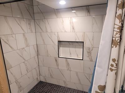 Marble tile shower interior with recessed niche