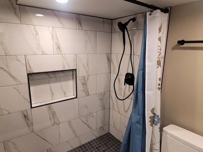 Marble tile shower wall with matte black hardware