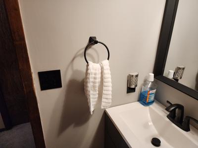 Vanity detail with matte black fixtures and framed mirror