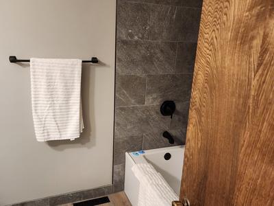 Tub shower surround with gray stone tile from above
