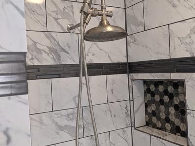 Marble shower with hexagonal mosaic niche