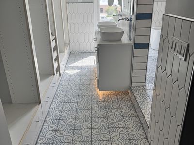 Farmhouse bathroom with encaustic tile floor and blue accent stripe