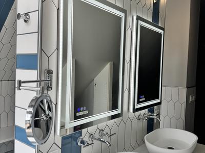 Picket tile wall with blue accent, dual vessel sinks and backlit medicine cabinets
