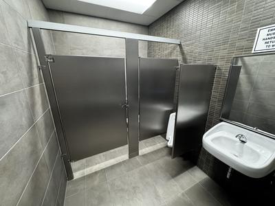 Commercial restroom buildout with large-format tile and mosaic accent wall