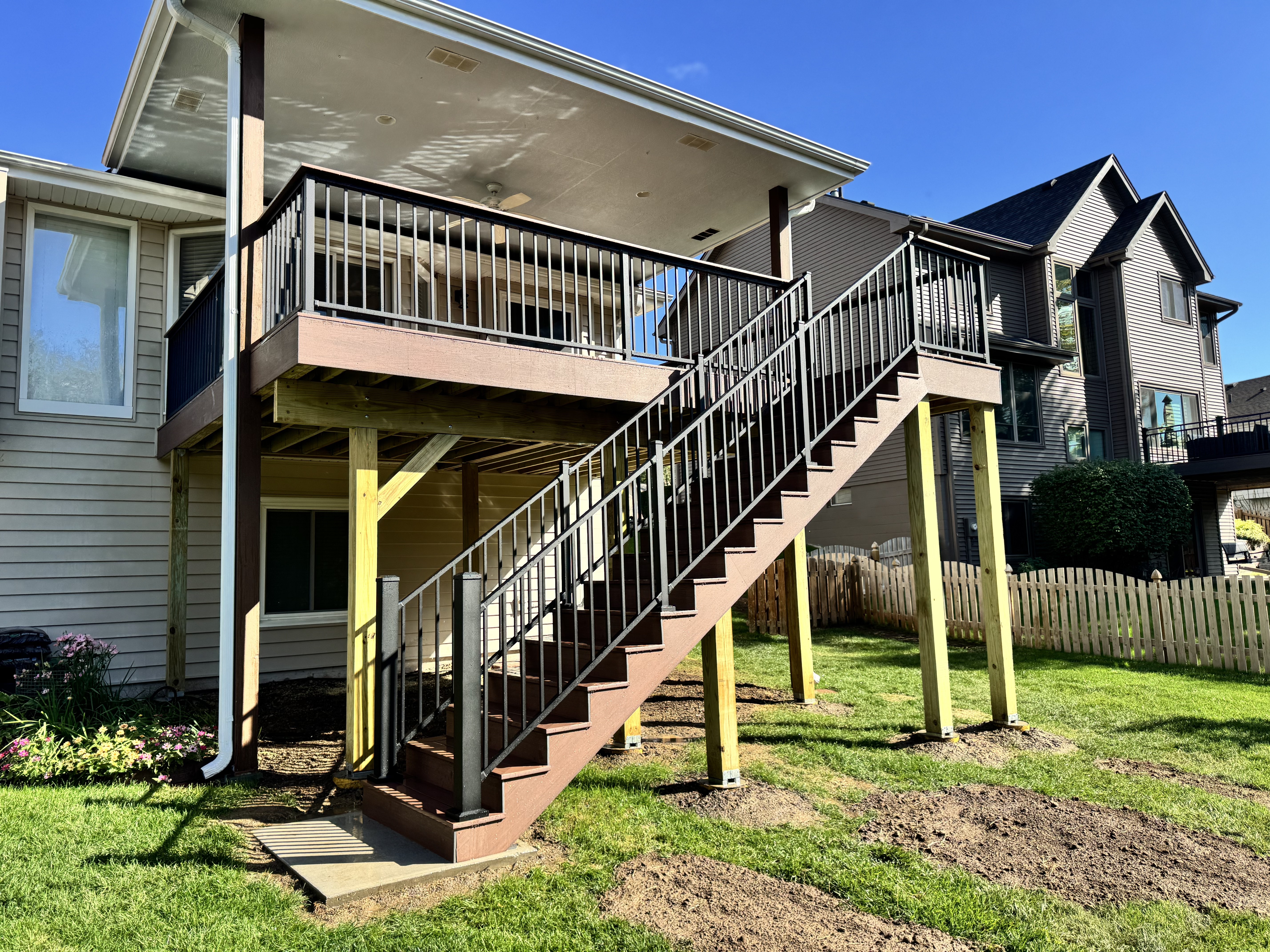 Finished composite deck with black metal railing by Bunz and Sonz Construction