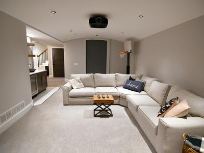Basement living area with projector and wet bar