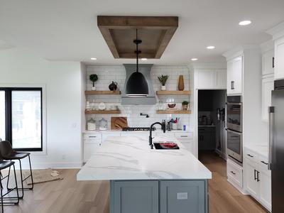 Modern kitchen with blue island and waterfall counters