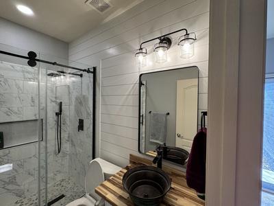 Farmhouse bathroom with shiplap and industrial lighting