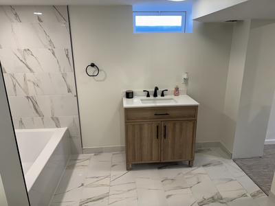 Basement bathroom with marble tile shower