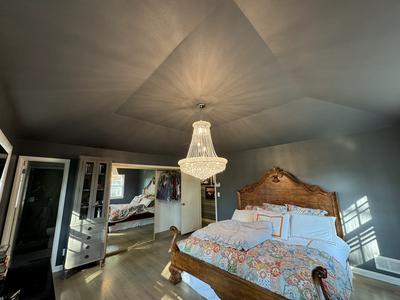 Master bedroom with vaulted ceiling and chandelier