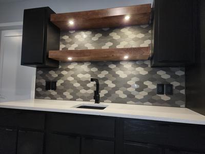 Wet bar with black shaker cabinets and LED shelves