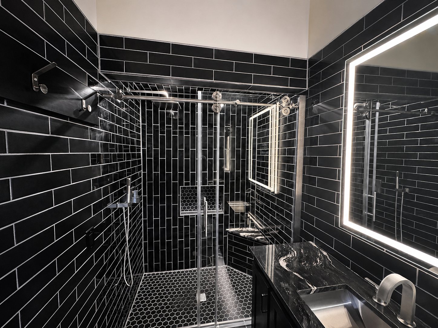 Black subway tile bathroom with walk-in shower and backlit mirror in Omaha